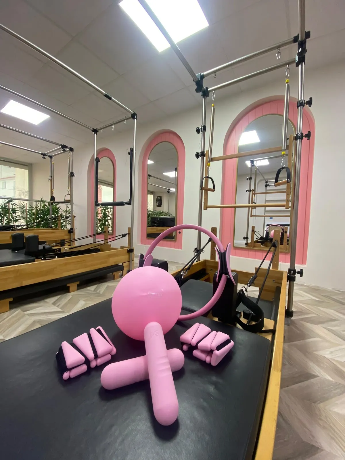 Reformer üzerinde hazır duran pilates topu, çemberi ve küçük ağırlıklar