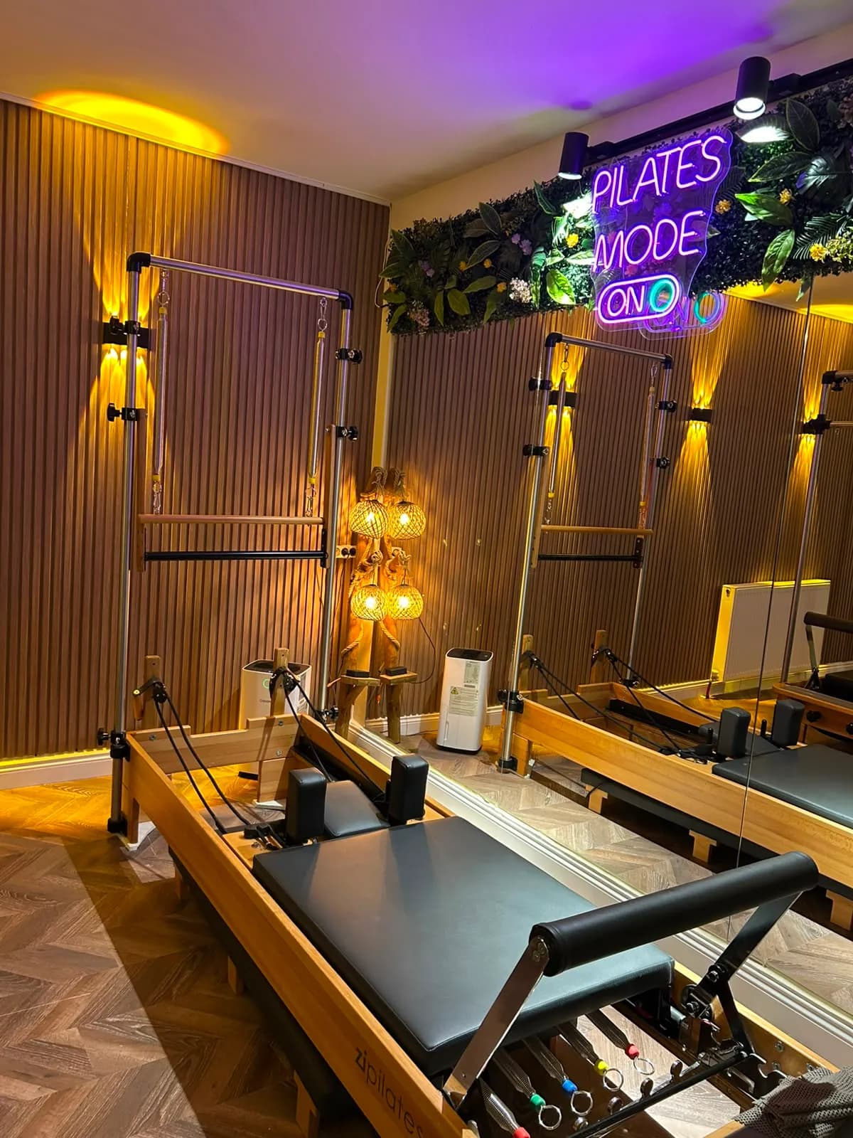 Saray stüdyosunun ahşap kaplamalı reformer salonu ve neon detayı